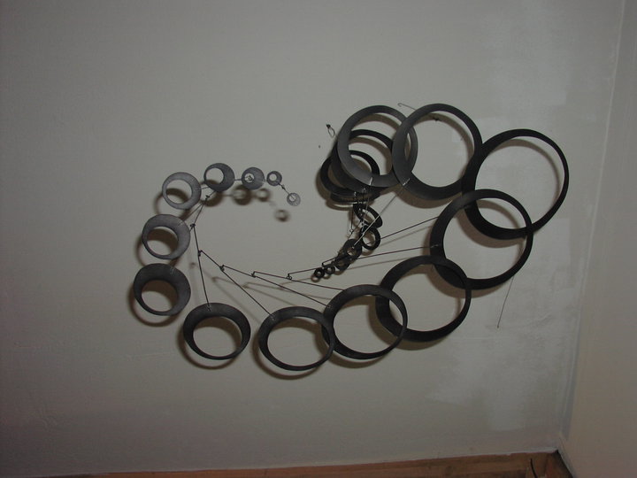 Black wire mobile with many horizontal hollow circle shapes.